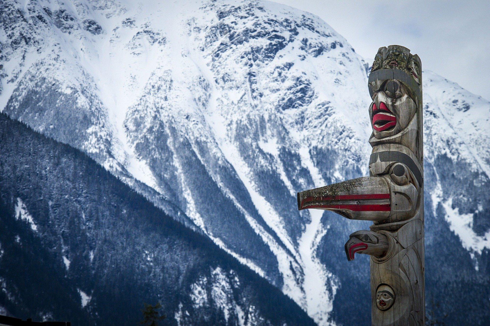 totem pole with mountains in the background