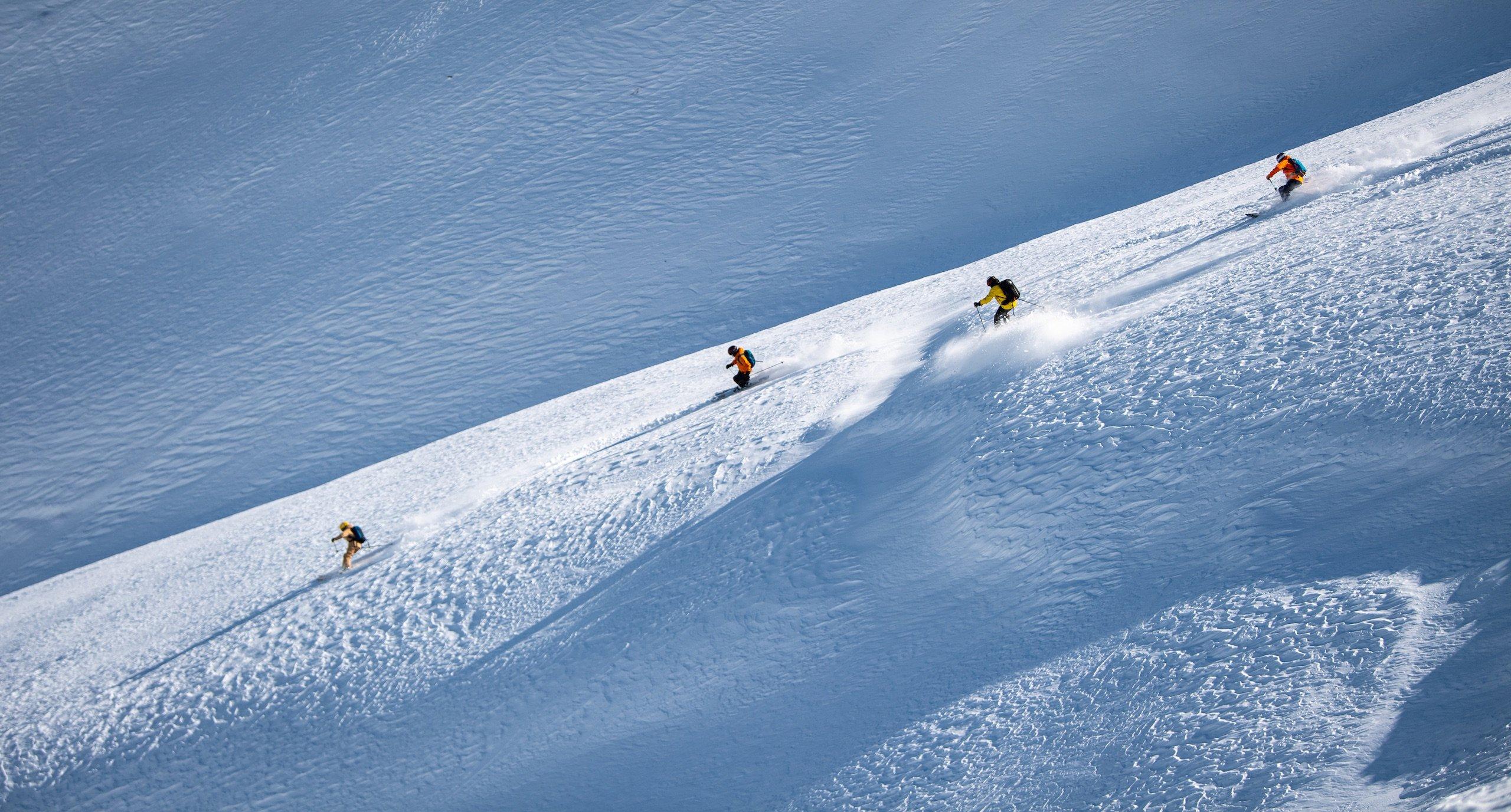 Four skiers descending a mountain