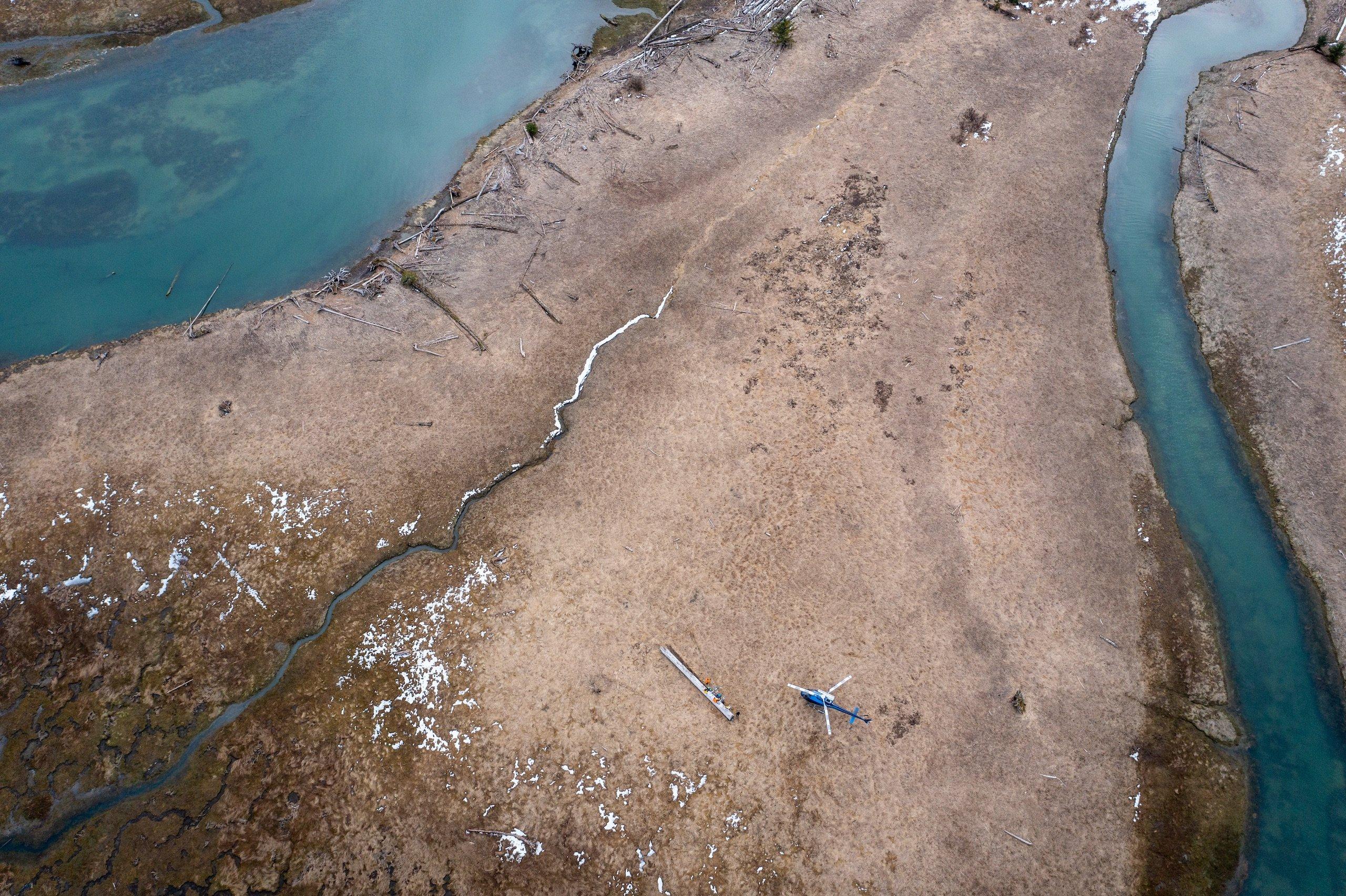 Aerial of beach area with helicopter next to the water