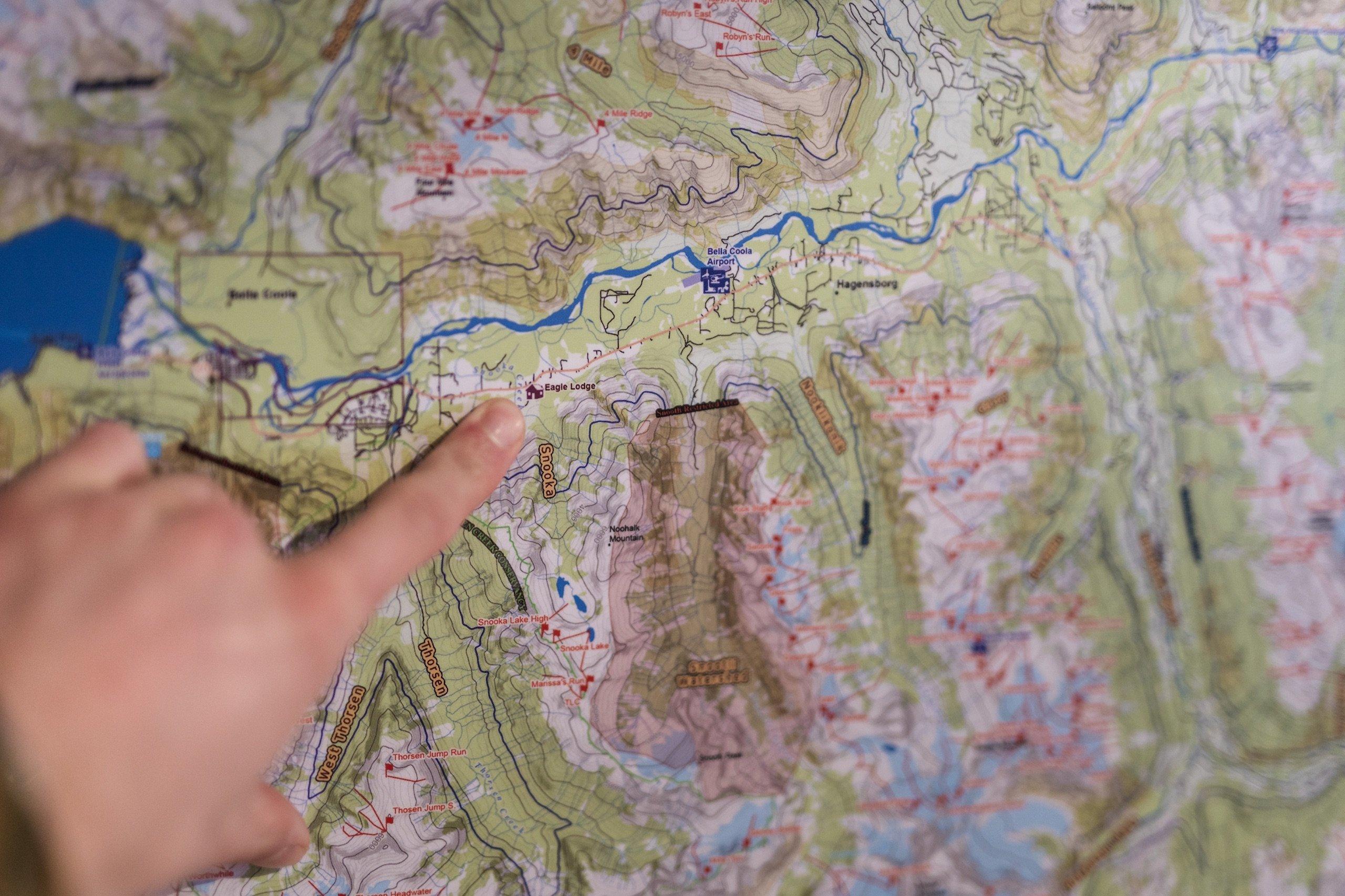 a hand pointing to Eagle Lodge on a map