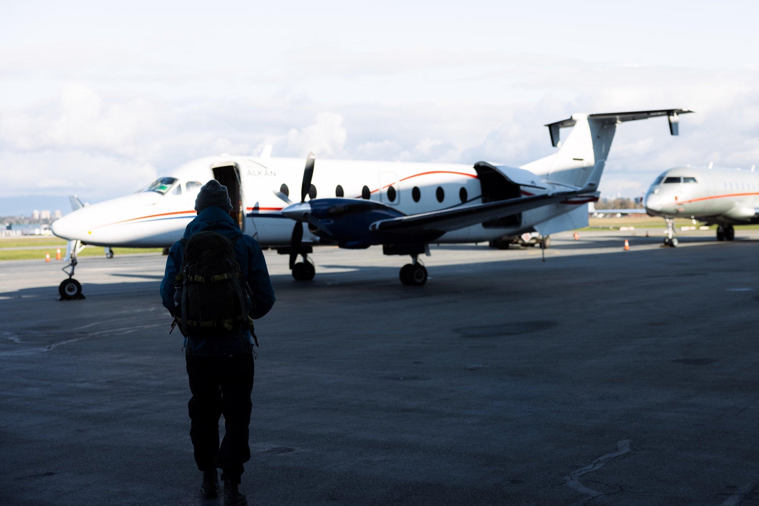 A man walking towards a small plane