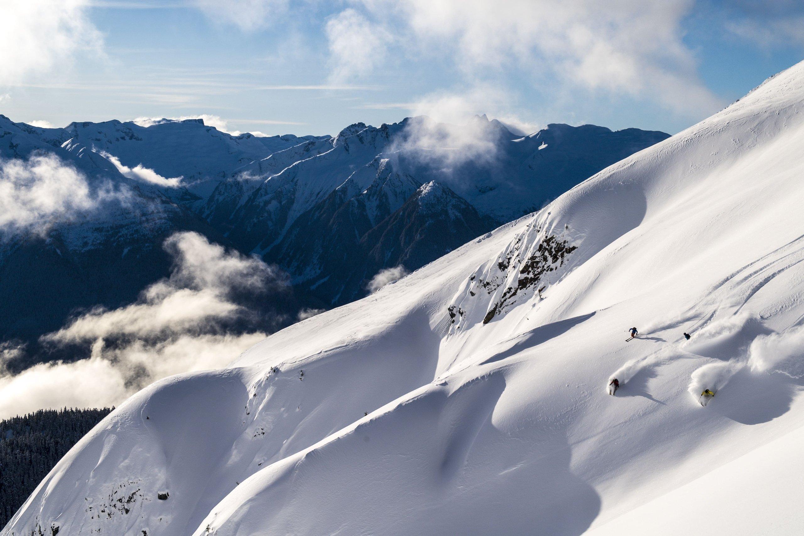 a group of skiers descending a mountainside